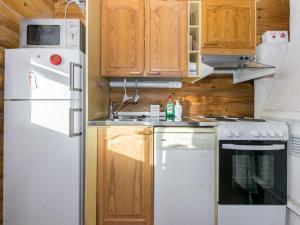 eine Küche mit weißem Kühlschrank und Holzschränken in der Unterkunft Holiday Home Alppi 7b paritalo by Interhome in Hyrynsalmi
