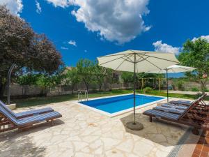 a pool with two chairs and an umbrella at Holiday Home Vrt - ROJ459 by Interhome in Sveti Petar u Šumi