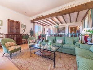 uma sala de estar com um sofá verde e cadeiras em Villa Son Maguet by Interhome em Selva