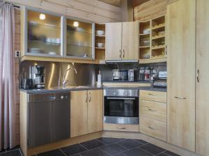 a kitchen with wooden cabinets and a stainless steel appliance at Holiday Home Haltinsaana by Interhome in Kilpisjärvi