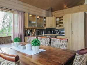 Il comprend une cuisine et une salle à manger avec une table et des chaises en bois. dans l'établissement Holiday Home Haltinsaana by Interhome, à Kilpisjärvi