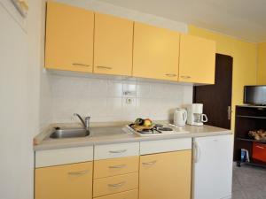 kuchnia z żółtymi szafkami i zlewem w obiekcie Holiday Home Gloria - RCA220 by Interhome w mieście Krnica