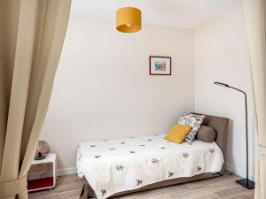 1 dormitorio pequeño con 1 cama y 1 silla en Studio Résidence le Cotre by Interhome, en Saint-Malo