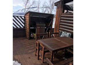 ein Holztisch und Stühle auf einer Terrasse in der Unterkunft Holiday Home Haltinsaana by Interhome in Kilpisjärvi