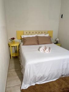 ein weißes Bett mit zwei Hunden auf dem Bett in der Unterkunft Villa da Serra Pousada in Piuí