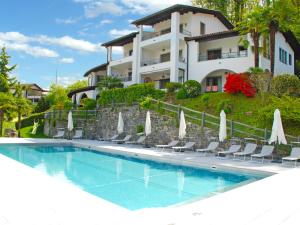 uma villa com piscina em frente a um edifício em Apartment Residence Miralago - Utoring Apt- B16 by Interhome em Piazzogna