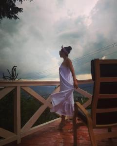 een vrouw in een witte jurk die op een hek staat bij Villa nagori in Slavske
