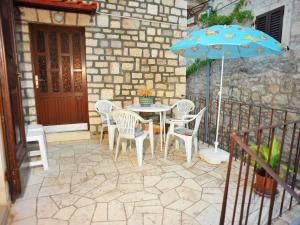 a patio with a table and chairs and an umbrella at Apartment Mirta-2 by Interhome in Sutivan