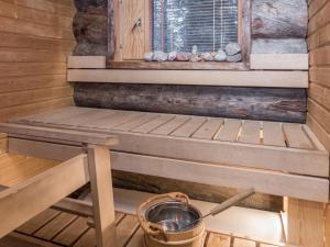 eine Holzsauna mit einem Eimer und einem Fenster in der Unterkunft Holiday Home Mäentähti b by Interhome in Ruka