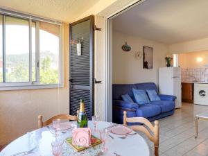 een woonkamer met een tafel en een blauwe bank bij Apartment Résidence Les Sangliers by Interhome in Saint-Raphaël
