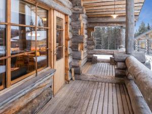 eine Holzveranda eines Blockhauses mit Fenstern in der Unterkunft Holiday Home Mäentähti b by Interhome in Ruka