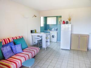 een woonkamer met een bank en een keuken bij Apartment Résidence Les Sangliers by Interhome in Saint-Raphaël