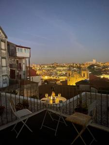 un tavolo e sedie su un balcone con vista sulla città di Douro Virtudes Apartments Historical Center a Porto