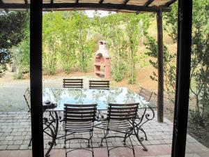 una mesa de cristal y sillas en un patio en Apartment Istrice-10 by Interhome, en Riparbella