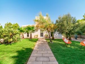 a house with two chairs in the grass at Villa Betlem by Interhome in Colonia de Sant Pere