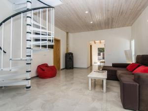 a living room with a couch and a spiral staircase at Villa Betlem by Interhome in Colonia de Sant Pere