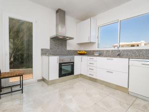 a kitchen with white cabinets and a large window at Villa Betlem by Interhome in Colonia de Sant Pere +15 photos