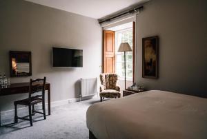 a bedroom with a bed and a desk and a chair at Forss House in Thurso