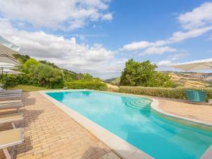 uma piscina com cadeiras e um guarda-sol em Holiday Home I Due Carpini-1 by Interhome em Citta' Sant'Angelo