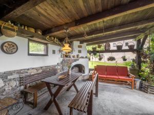 a patio with a wooden table and benches and a fireplace at Holiday Home Újezd Svatého Kříže by Interhome in Bělá nad Radbuzou