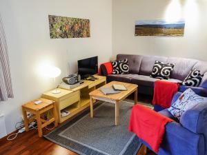 a living room with a couch and a tv at Holiday Home Saariseläntie 8 a 1 by Interhome in Saariselka