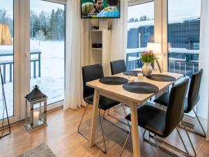 una sala da pranzo con tavolo, sedie e TV di Holiday Home Willa anna b by Interhome a Dragsfjärd