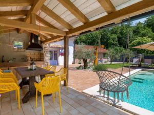 een patio met een tafel en stoelen en een zwembad bij Holiday Home Villa Antonio by Interhome in Jurdani