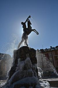 una estatua de dos personas saltando en una fuente en Il Fauno, en Asiago