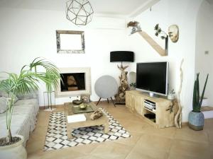 a living room with a couch and a tv at La BouganVilla Charme & Relax vista mare in Finale Ligure