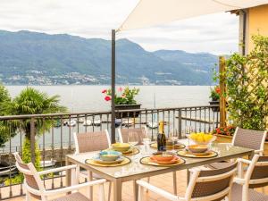 een tafel op een balkon met uitzicht op het water bij Apartment Atmosfere sul lago by Interhome in Porto Valtravaglia