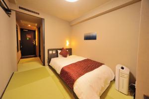 Säng eller sängar i ett rum på Tennen Onsen Taho-no-Yu Dormy Inn Niigata