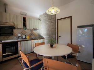 a kitchen with a table and chairs in a kitchen at Apartment Residenza Agrifoglio-17 by Interhome in Luino