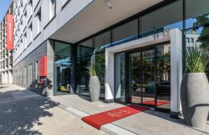 a building with glass doors and potted plants on the sidewalk at Leonardo Hotel Dortmund in Dortmund
