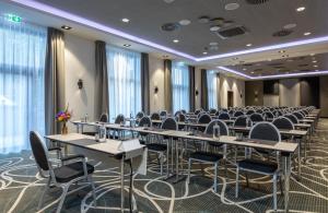 uma sala de conferências com fileiras de mesas e cadeiras em Leonardo Hotel Dortmund em Dortmund