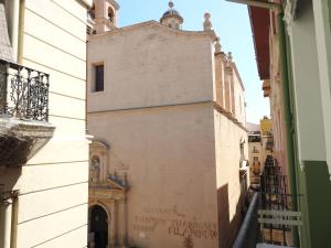 a view of a building from a narrow alley at Habitaciones Amelia in Alicante