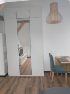 einen Spiegel in einem Zimmer mit einem Tisch und einem Stuhl in der Unterkunft Bad Aibling City Apartment DG in Bad Aibling