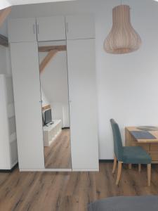 espejo en una habitación con mesa y silla en Bad Aibling City Apartment DG, en Bad Aibling