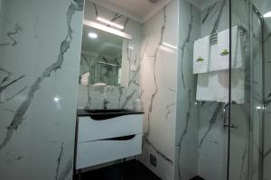 Baño blanco con lavabo y espejo en Hotel Quinta do Viso, en Miranda do Corvo