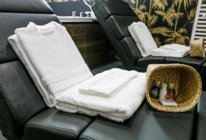 a room with a couch with a towel and a chair at La Suite by Suite Spa Privatif in Pontavert