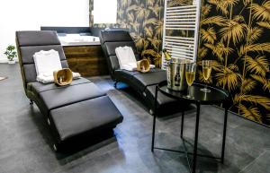Pontavert的住宿－Suite Spa Privatif，一间设有两把椅子和一张桌子及香槟杯的房间