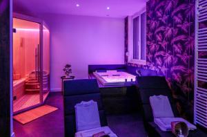 Pontavert的住宿－Suite Spa Privatif，紫色的客房配有浴缸和2把椅子