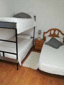 伊維的住宿－Habitaciones en casa rural particular La Casita，一间卧室设有两张双层床和床头柜。