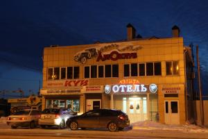 a building with cars parked in front of it at Aelita Hotel in Volgodonsk
