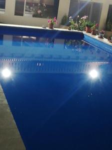 uma piscina azul com luzes numa casa em Habitaciones en casa rural particular La Casita em Ibi