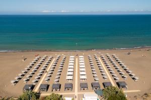 una vista aerea di un parcheggio con spiaggia di Tuscany Hotel Alle Dune a Marina di Castagneto Carducci