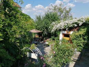 einen Garten mit einem Tisch, Stühlen und Blumen in der Unterkunft Pension Amelie in Mörbisch am See