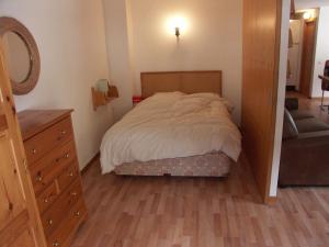 sypialnia z łóżkiem, komodą i lustrem w obiekcie Apartment Cristal 505A w mieście Anzère