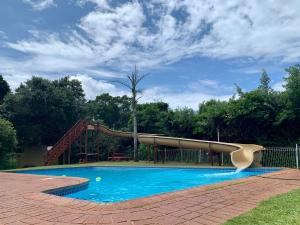 eine Rutsche in einem Pool mit Spielplatz in der Unterkunft Mtunzini Forest Lodge Self Catering Resort in Mtunzini