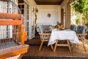 a dining room with a table and chairs on a porch at DELUXE VILLA BELLA VITA AIR CON & HEATED POOL, Tenerife South in Chayofa