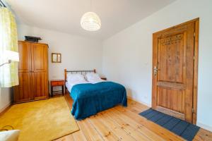 sypialnia z łóżkiem i drewnianą podłogą w obiekcie Apartament Na Skraju Miasta w mieście Mikołajki